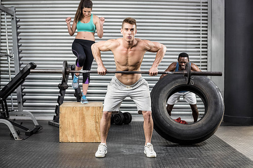 Fit people exercising together at crossfit gym