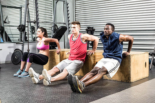 Fit people exercising together at crossfit gym