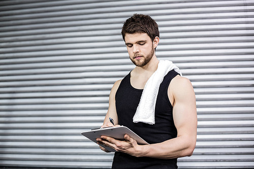 Trainer taking notes at crossfit gym at crossfit gym