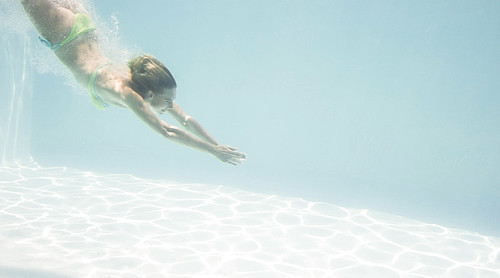 Fit woman swimming under water in the pool