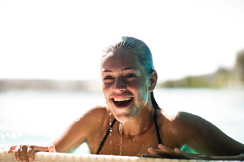 Beautiful blonde in the pool smiling and breathing