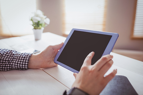 Businesswoman using her tablet at her desk in office