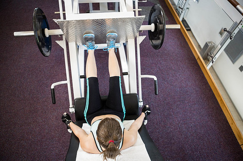 Fit brunette doing exercises for legs at the gym