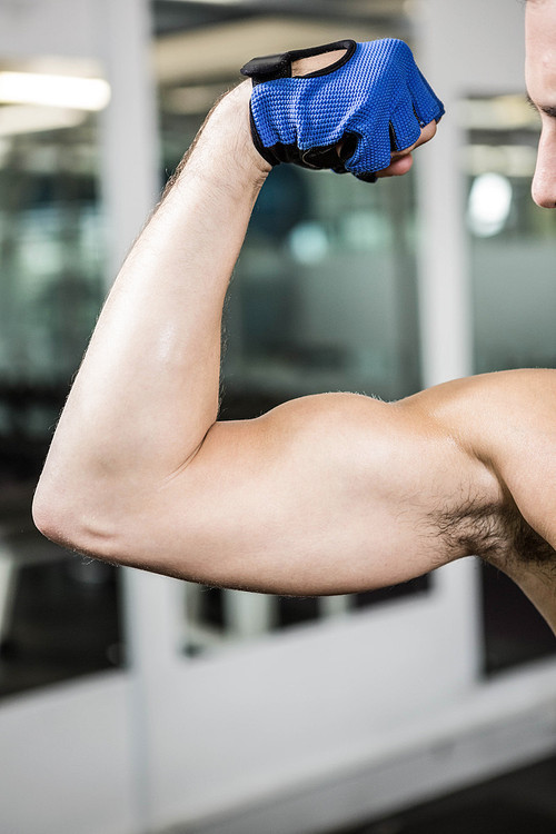 Muscular man showing biceps at the gym