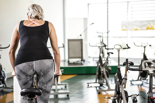 Fit woman on exercise bike at the gym