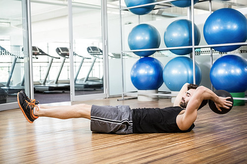 Man doing exercise with medicine ball in the studio