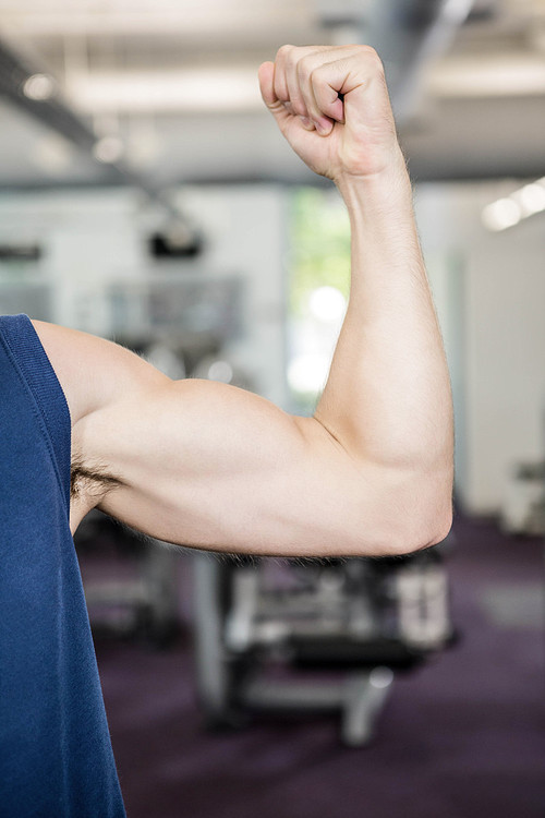 Close up of man showing biceps at the gym