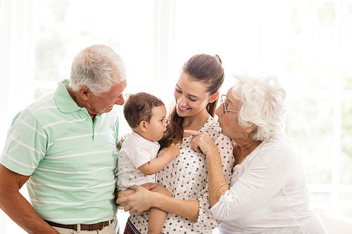 Happy grandparents playing with their grandson at home