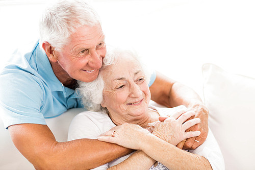 Cute senior couple hugging on sofa