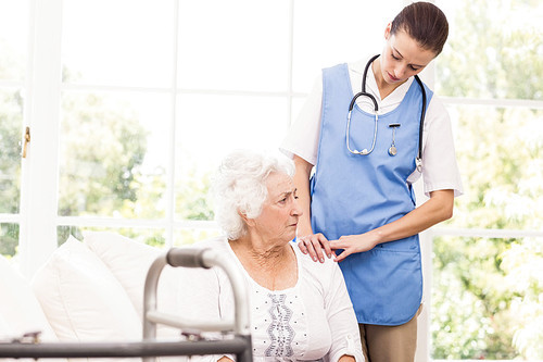 Nurse taking care of sick elderly woman at home