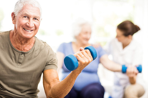 Physiotherapist helping patients with exercises at home