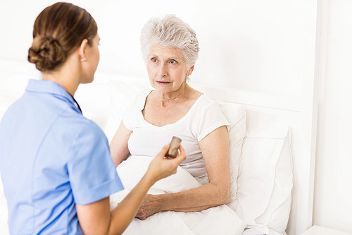 Nurse taking care of suffering senior patient at home