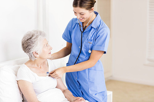 Doctor taking care of suffering senior patient at home