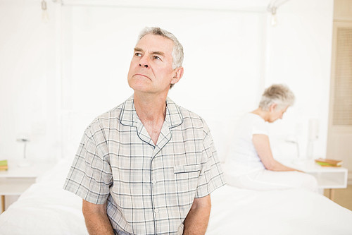 Annoyed couple ignoring each other in the bedroom