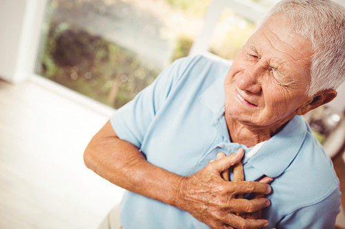 Painful senior man with pain on heart at home