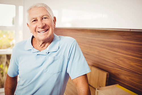 Senior man standing and looking at the camera at home