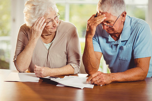 Senior couple counting bills at home
