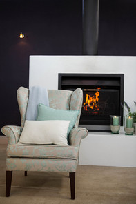 Armchair next to fireplace at home