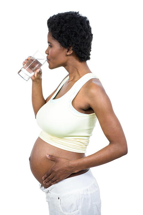 Pregnant woman drinking water on white background