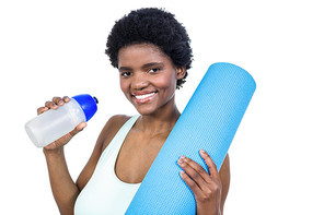 Pregnant woman holding water bottle and mat on white background