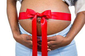 Pregnant woman with ribbon on bump on white background