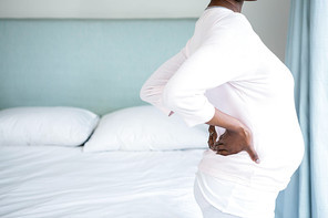 Pregnant woman with back pain in bedroom
