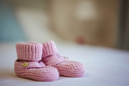 View of baby shoes on a bed at home