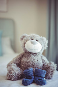 View of teddy bear and baby socks on a bed