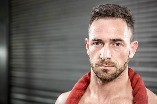 Portrait of shirtless man with battle rope around neck at the crossfit gym