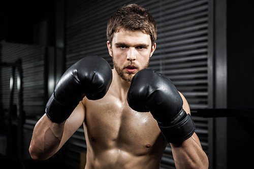 Shirtless man with boxe gloves at the crossfit gym