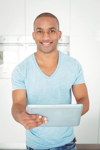 Smiling man using tablet in the kitchen