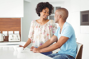 Smiling couple in the kitchen talking