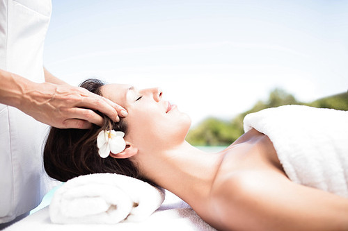 Woman receiving a head massage from masseur in a spa