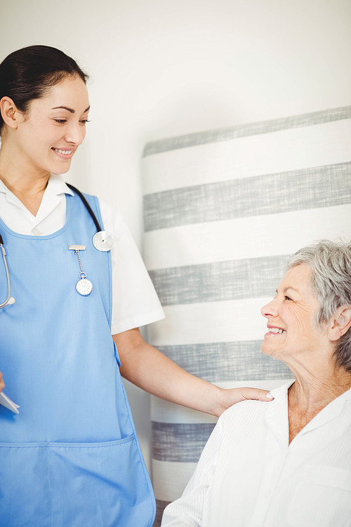 Nurse taking care of sick senior woman in bedroom