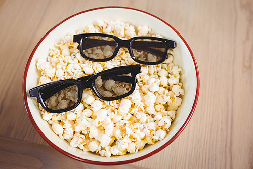Close-up of 3D glasses in bowl of popcorn on table