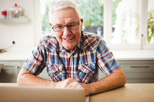 Senior man using laptop at home