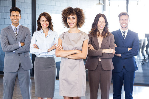 Portrait of confident business team standing in office with their hands crossed