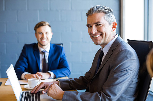 Businessman working on laptop in a conference room during meeting at office