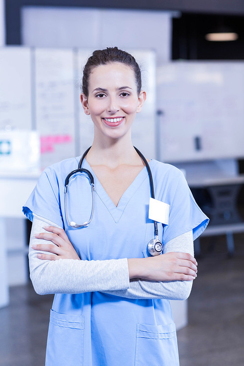 Female doctor standing with arms crossed and smiling in hospital