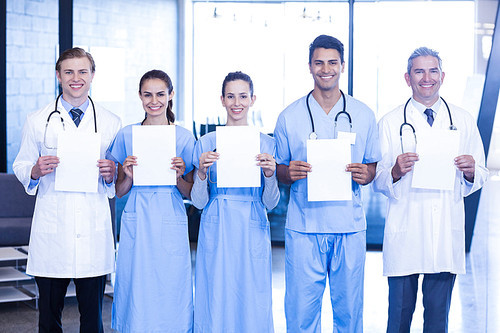 Portrait of doctors showing medical reports in hospital