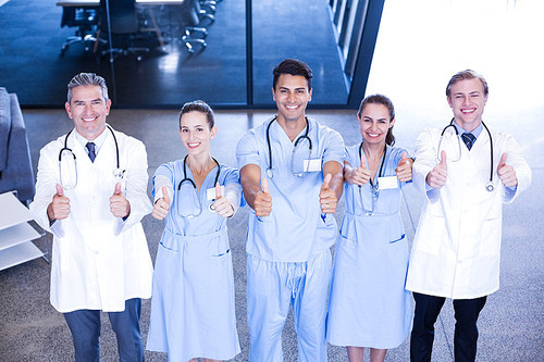 Portrait of medical team putting their thumbs up and smiling