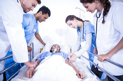 Doctors examining a patient on bed in hospital