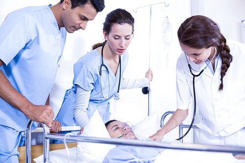 Doctors examining a patient on bed in hospital