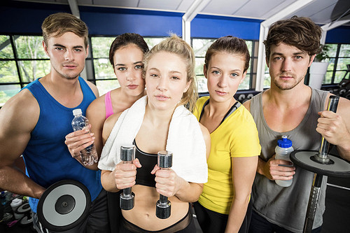 Athletic men and women posing at crossfit gym