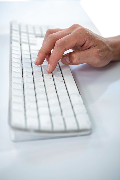 Close up view of a male hand typing on keyboard on white background