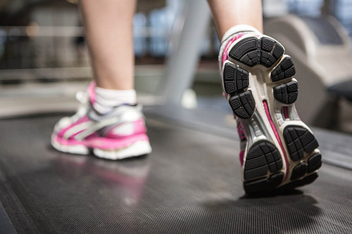 Feet of a woman on a treadmill in a gym