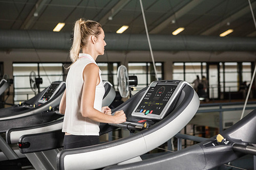 woman exercising on a treadmill at the gym