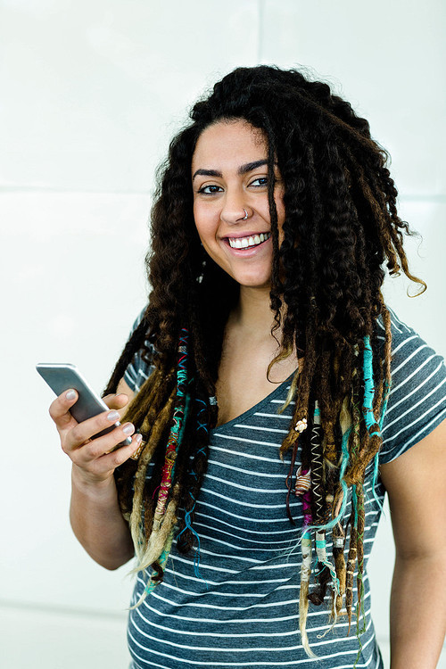 Portrait of woman smiling while typing a text message