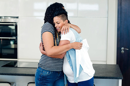 Lesbian couple embracing each other at home