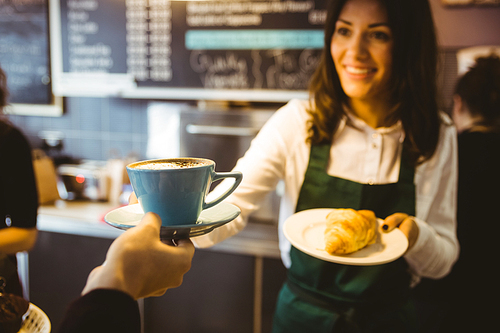 Waitress serving a cup of coffee in cafe